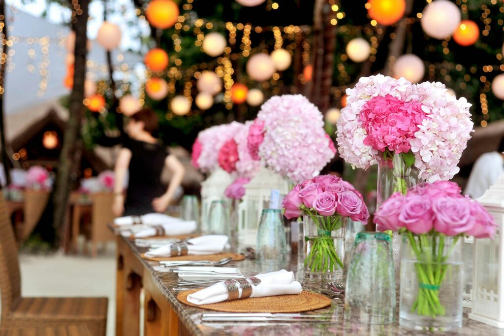 Elegant outdoor wedding setup featuring pink floral arrangements and soft lighting.