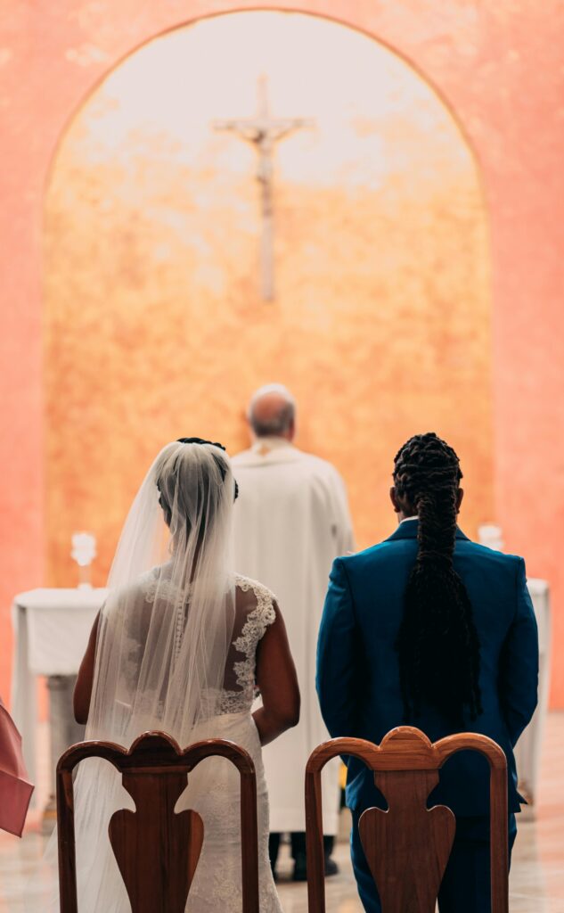 Bride and groom stand before an altar in a sacred church ceremony, symbolizing togetherness and love.